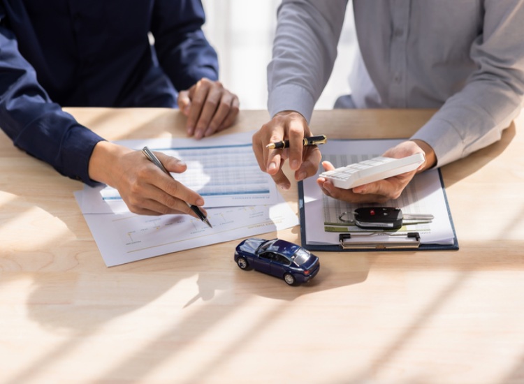 Customer and agent discussing car insurance paperwork in Natick, MA